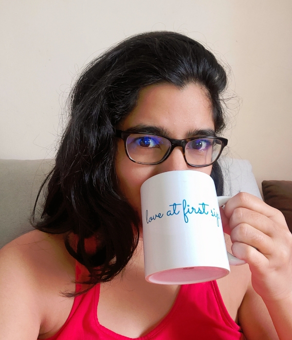 Zaïra, co-founder of MyTeaBox, sipping tea from a mug with "love at first sip" written on it.